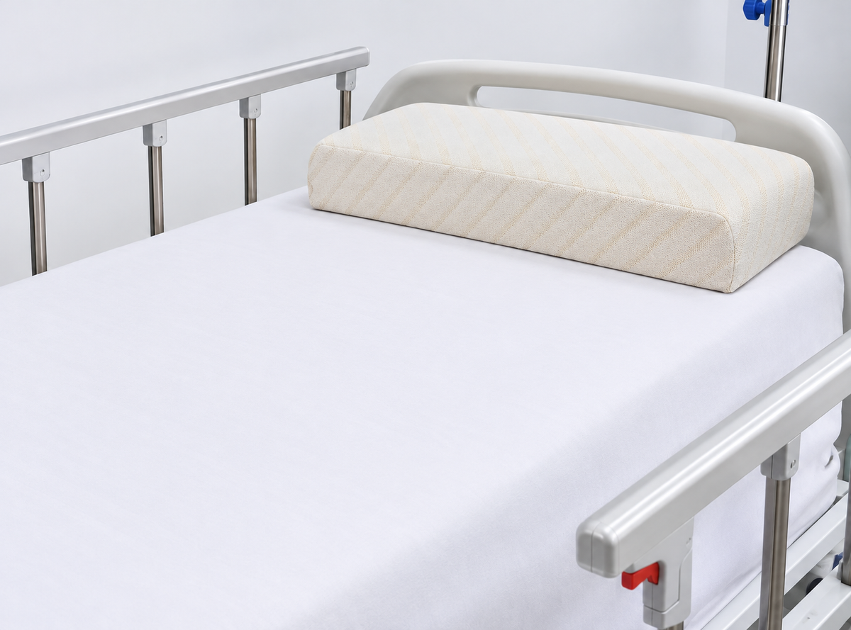 Almohada cervical ergonómica en espuma viscoelástica AM19 de Home Care Technology sobre cama hospitalaria Imagen principal del producto